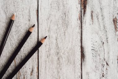 Ahşap arka plan üzerinde renkli kömür kalemler grubu