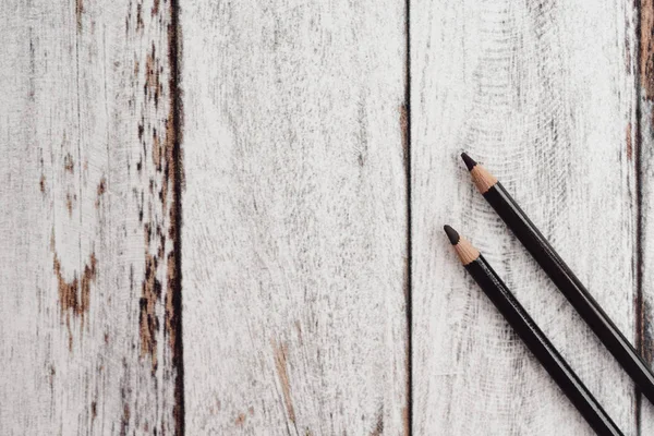 Ahşap arka plan üzerinde renkli kömür kalemler grubu