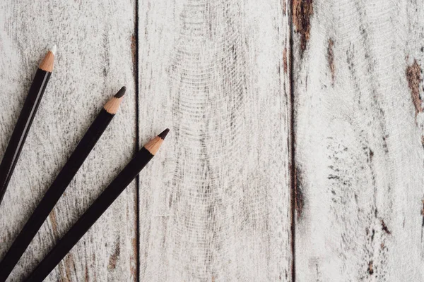 Ahşap arka plan üzerinde renkli kömür kalemler grubu