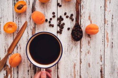 Bir fincan kahve kayısı, ahşap bıçak ve c ile tutan el