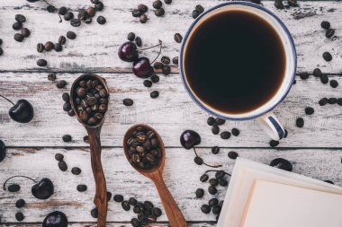fasulye, tahta kaşıklar ve kiraz ahşap arka plan üzerinde siyah kahve