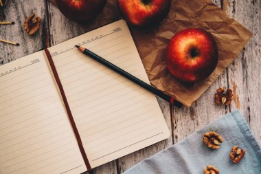 Ahşap ve mavi arka plan üzerinde bir tarif kitabı-elma ceviz ve kaşık yemek