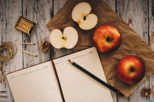 Cocinar un libro de recetas con nueces de manzana y cuchara sobre fondo de madera y azul — Foto de Stock