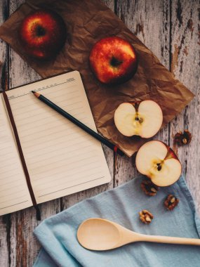 Ahşap üzerinde elma ceviz ve kaşık bir tarif kitabı yemek ve