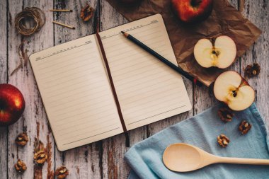 Ahşap üzerinde elma ceviz ve kaşık bir tarif kitabı yemek ve