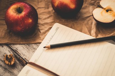 Ahşap üzerinde elma ceviz ve kaşık bir tarif kitabı yemek ve