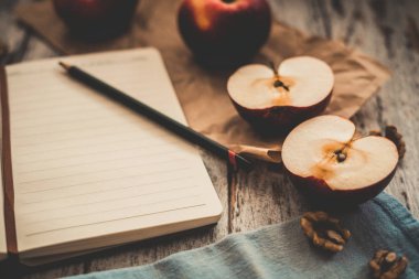 Ahşap üzerinde elma ceviz ve kaşık bir tarif kitabı yemek ve