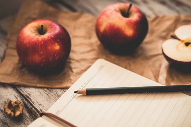 Ahşap üzerinde elma ceviz ve kaşık bir tarif kitabı yemek ve