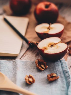 Ahşap üzerinde elma ceviz ve kaşık bir tarif kitabı yemek ve