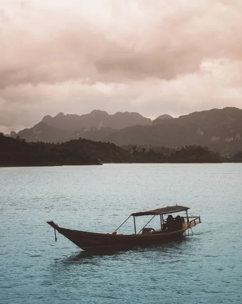 Deniz suyu uzak kayalar ve bulutlu gökyüzü teknede Kano