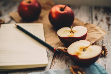 Ahşap üzerinde elma ceviz ve kaşık bir tarif kitabı yemek ve