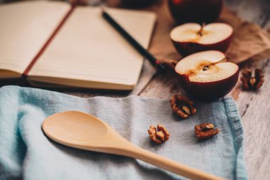 Ahşap üzerinde elma ceviz ve kaşık bir tarif kitabı yemek ve