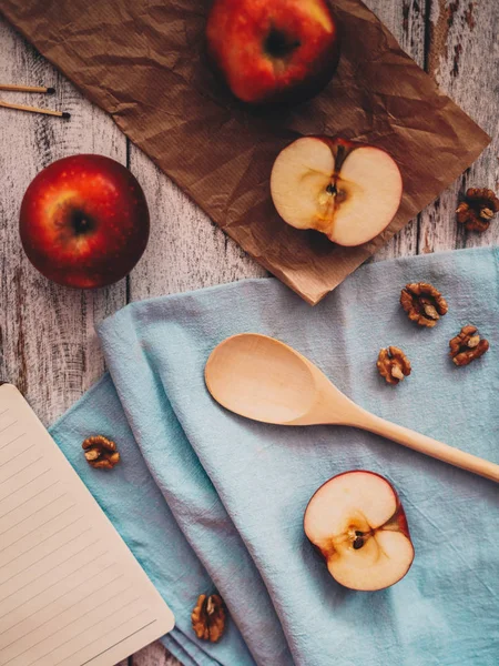 Memasak buku resep dengan apel kenari dan sendok di kayu dan Stok Foto Bebas Royalti