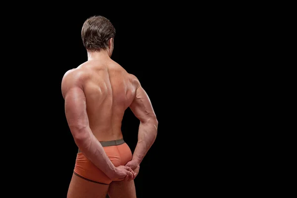 Güçlü adam geri siyah arka plan üzerine poz