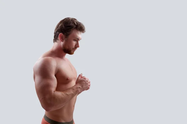 Gri arka plan üzerinde meditasyon bir genç sakallı kaslı adam portresi