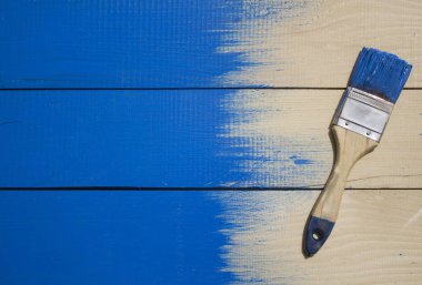 Ahşap zemin üzerine mavi boya ile fırça