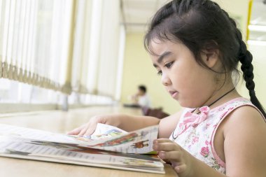 Çocuklar kütüphanede kitap okuyor. Okuma öğrenmek için en iyi yoldur