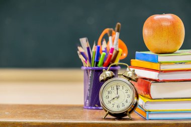 Başarılı olmak için yardımcı olur çünkü blackboard boş, eğitim herkes için önemli olan bu. Öğretim harekete geçirmek için ön yan kitap yığılmış ve bir kalem durumda, çalar saat ve kırmızı elma vardır.