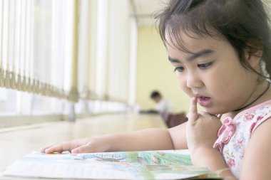 Çocuklar kütüphanede kitap okuyor. Okuma öğrenmek için en iyi yoldur