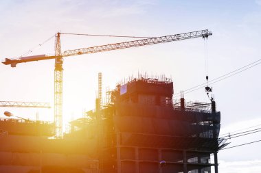 Büyük bir bina inşaatı almak için araçlar, akşam atmosferde çalışmalarında uzmanlaşmış mühendis, güneşin düşen.