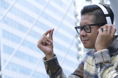 Müzik yaşam için gerekli zihin sakin yardım, erkekler kulaklık ile müzik dinlemek ve fiske, yapışma Internet sinyal, Bluetooth ile bağlan kullanarak bir ekose gömlek ve gözlük giymek.