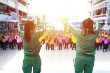 Bulanık fotoğraf, sınıf - bir grup insan 2 eğitmenler ile egzersiz Step Aerobik egzersiz egzersiz, bir yeşil kazak vermek için öğrencilerin bir sürü çok renkli tonları öğrencilere öğretiyor