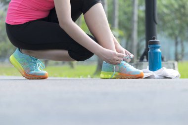 Vücut sağlıklı tutmak için egzersiz, kadınlar pembe gömlek giymek ve siyah pantolon ayakkabı bağlamayı shrunk, bir havlu ve bir su şişesi tarafta yer alır.