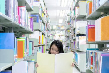 Çocuklar kütüphanede kitap okuyor. Okuma öğrenmek için en iyi yoldur