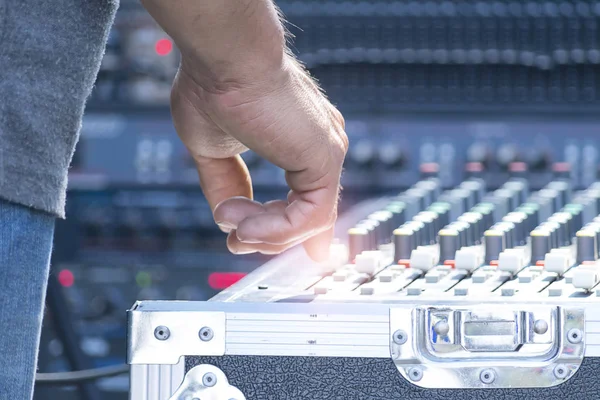 Sound technician and lights technicians control the music show in concert.Professional audio, light mixer controller panel.Pro equipment for concerts.Stage lighting control.Hand adjusting audio mixer