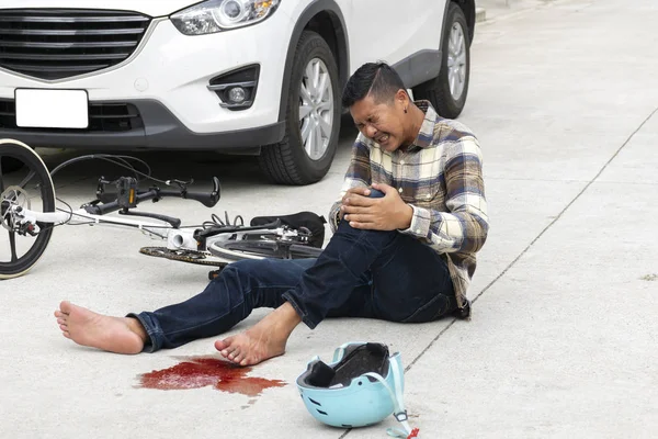 Bicycle accident on the road. Unexpected accidents, men riding bicycles and then hit a car accident. The wound so much bleeding. The equipment used to ride the Bicycle is broken.