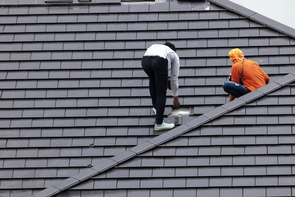 Workers are repairing the roof. To prevent sunlight and rain that will cause problems to the residents.