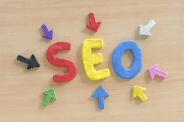 SEO, Search Engine Optimization ranking concept, with arrows pointing to alphabets abbreviation SEO at the center of wooden table, the idea of promote traffic to website.