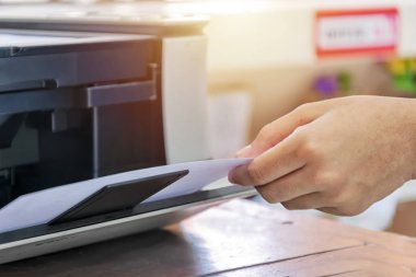 Yazıcıyı kullanarak. Yazdırma bitirdikten sonra kağıt tutan el. Ofiste önemli bir cihazdır.