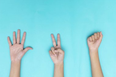 Taş, kağıt, makas - eller üzerinde mavi arka plan izole. Klasik bir maç olacak. Arkadaşlar arasında başarılı bir kapatma yapın.