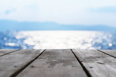 Bir ahşap zemin cephesidir. Mavi arka plan. Güzel bokeh göz alıcı. Doğal renkler çekici görünüyor. Deniz yüzeyi üzerine düşünceler