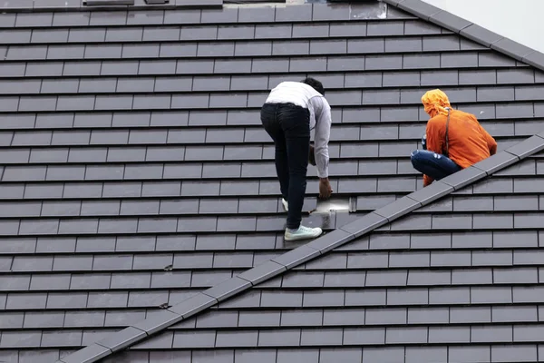 労働者は 屋根を修復します 日光と住民に問題を引き起こす雨を防ぐために — ストック写真