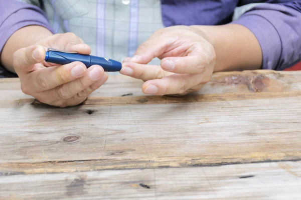 Nahaufnahme mit Lancelet am Finger zur Kontrolle des Blutzuckerspiegels — Stockfoto