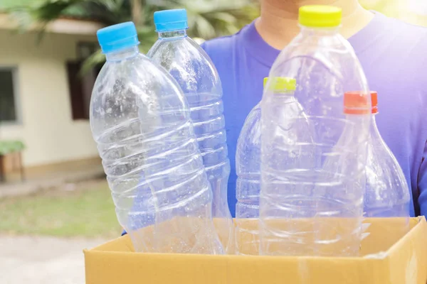 Adam plastik şişeile bir kağıt kutu tutar. Produ şişe için — Stok fotoğraf