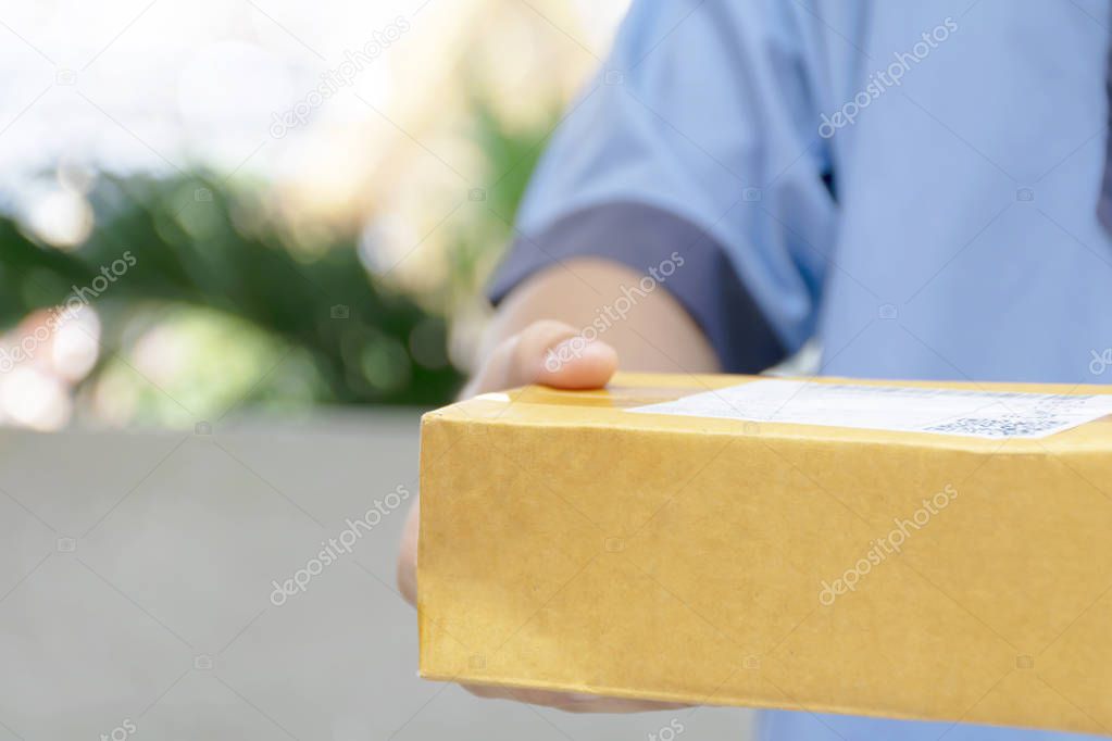 Closeup hands of delivery man holding package to deliver.