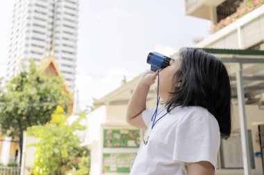 Beyaz gömlek giyen kızlar mavi dürbün kullanıyorlar..