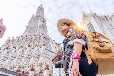 Kadın turist, Bangkok Tayland 'da Chao Phraya nehri üzerinde Wat Arun' u geziyor ve geziyor. Bir kamerası, haritası, hasır şapkası, güneş gözlüğü vardı..