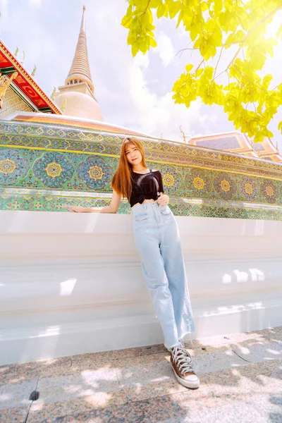美しいアジアの女性がタイのバンコクの寺院に立っています — ストック写真