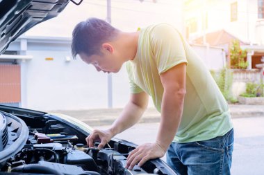 Otomobil tamircisi araba motorunu kontrol ediyor, işçi