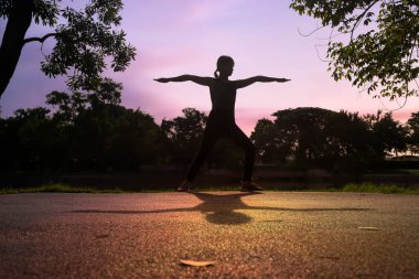 Dişi koşucular parkta koşmadan önce egzersiz yapıyor ve bacaklarını esnetiyorlar..