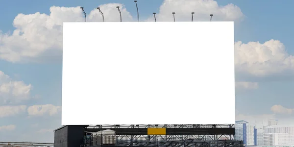 A large blank billboard against a blue sky. A blank canvas waiting for its next message. A wide shot of an empty billboard in an outdoor setting, against a blue sky with some clouds. Clipping path.