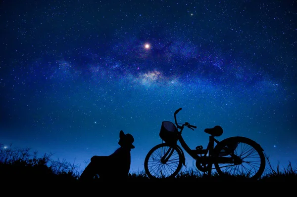 人は星の銀河の真ん中でサイクリングをしている — ストック写真