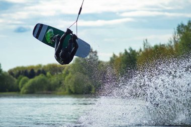 Wakeboardcu numaralar yapıyor. Düşük açılı adam gölde wakeboard yaparken..