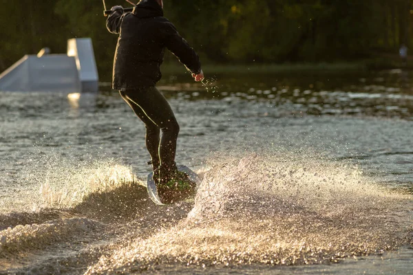 Wakeboarder che fa scherzi. Basso angolo colpo di uomo wakeboard su un lago . — Foto Stock