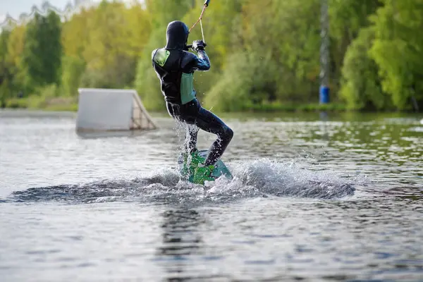 Wakeboardista dělá triky. Nízký úhel záběr člověka wakeboarding na jezeře. — Stock fotografie