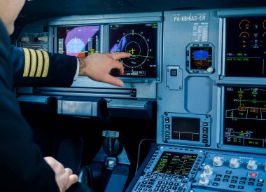 Pilot modern jet yolcu uçağı uçuş güvertesinde çalışıyor.